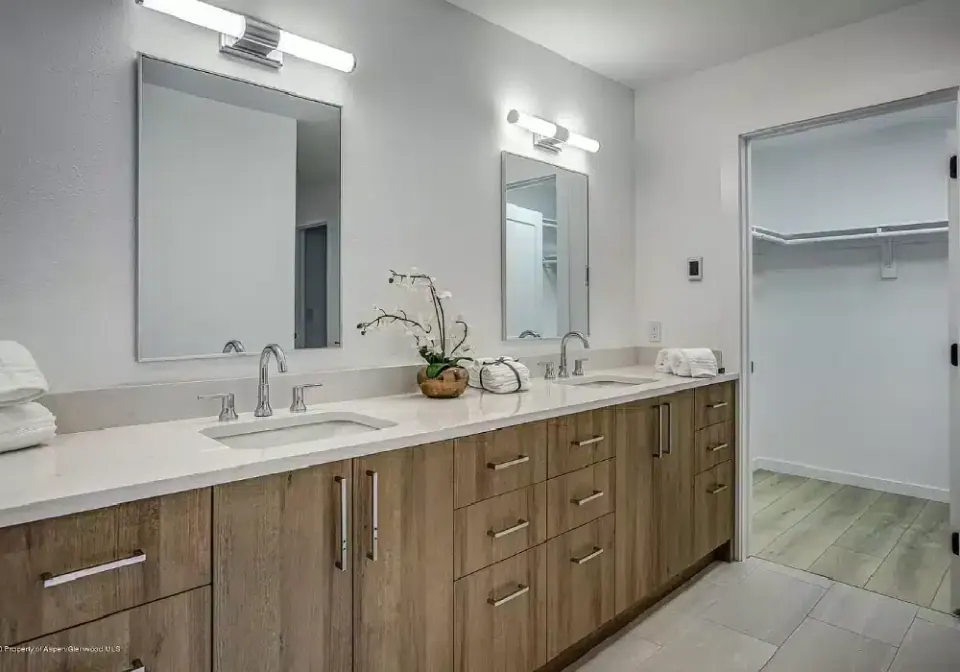 Powder room with patterned wallpaper and round mirror
