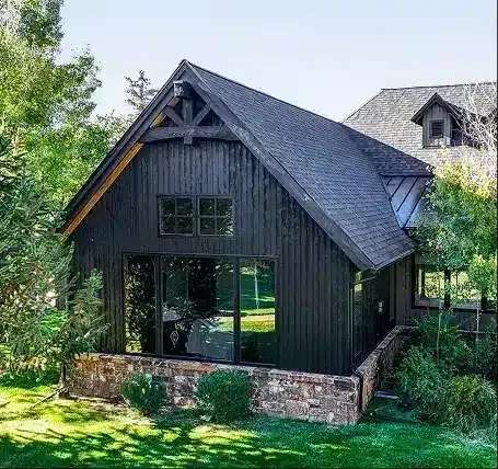 Dark-sided mountain home exterior with stone base