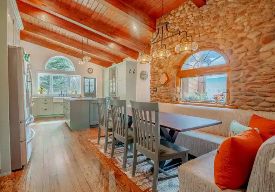 Dining nook with bench seating beside a stone wall