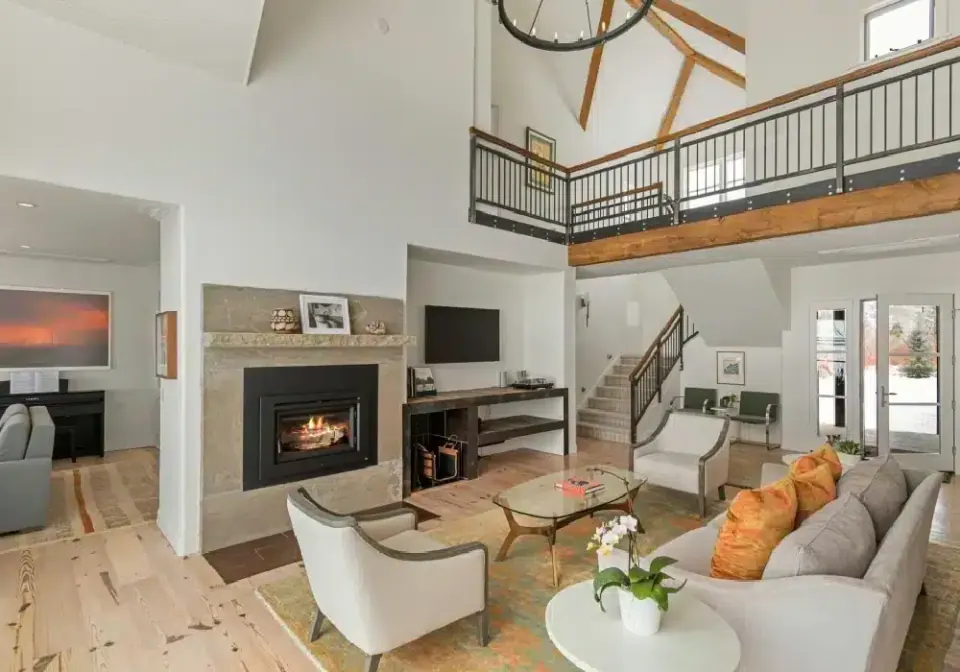 Remodeled living room with fireplace and open loft above